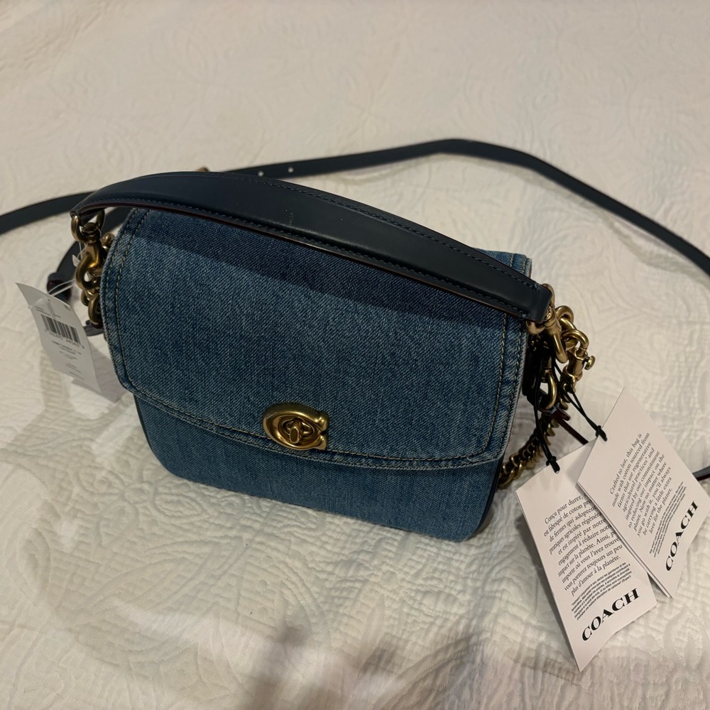 Brand new Coach denim purse. Small tear on leather of handle.